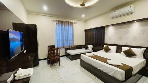 a bedroom with a large bed and a flat screen tv at Hotel Pushkar Town in Pushkar