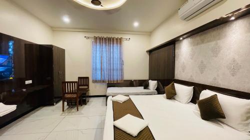 a hotel room with two beds and a desk and chair at Hotel Pushkar Town in Pushkar