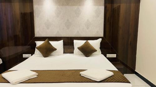 a bedroom with a bed with white sheets and pillows at Hotel Pushkar Town in Pushkar