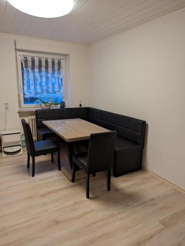 a dining room with a couch and a table and chairs at Wohnung "Margit" in Stadtallendorf