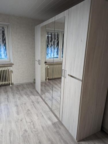 an empty room with glass doors and wooden floors at Wohnung "Margit" in Stadtallendorf