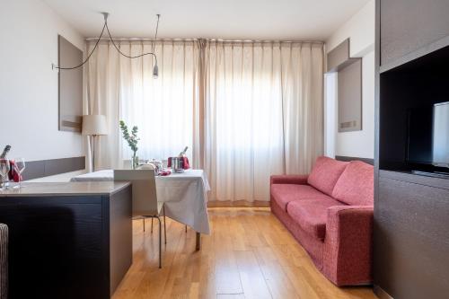 a living room with a pink couch and a table at Wall Art Hotel & Residence in Prato