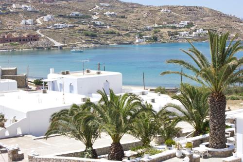 a view of a beach with palm trees and buildings at Anixi - Primavera Mykonos in Ornos