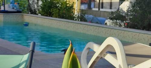 a swimming pool with two chairs next to a swimming pool at Kyrios Arts Atelier with use of private swimming pool in Carrascal