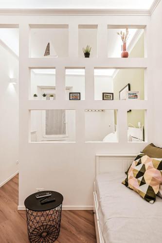 a bedroom with white walls and a bed with a black stool at Mascardi29 in Sarzana