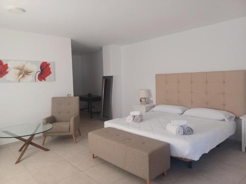 a bedroom with a large bed and a glass table at Villa Can Goldi con vistas al mar in Sant Josep