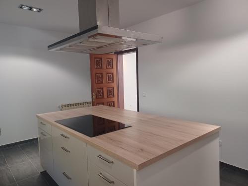 a kitchen with a wooden counter top and a stove at Villa Can Goldi con vistas al mar in Sant Josep