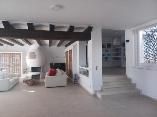a living room with white walls and a wooden ceiling at Villa Can Goldi con vistas al mar in Sant Josep