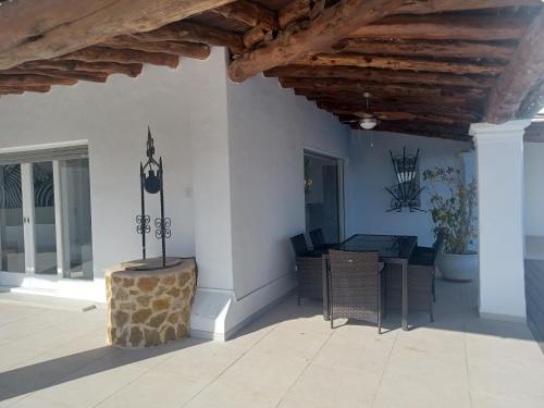 a patio with a table and chairs and a wooden ceiling at Villa Can Goldi con vistas al mar in Sant Josep