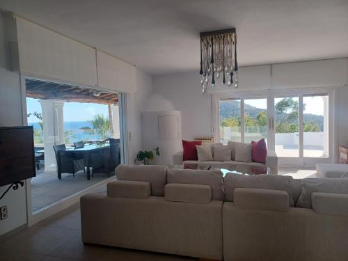 a living room with a couch and a dining room at Villa Can Goldi con vistas al mar in Sant Josep