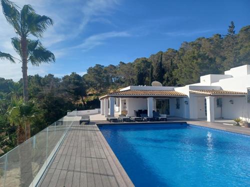 a swimming pool in front of a house at Villa Can Goldi con vistas al mar in Sant Josep