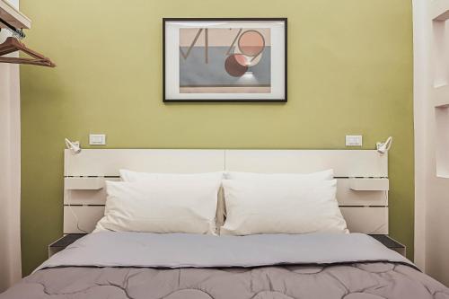 a bedroom with a bed with a picture on the wall at Mascardi29 in Sarzana