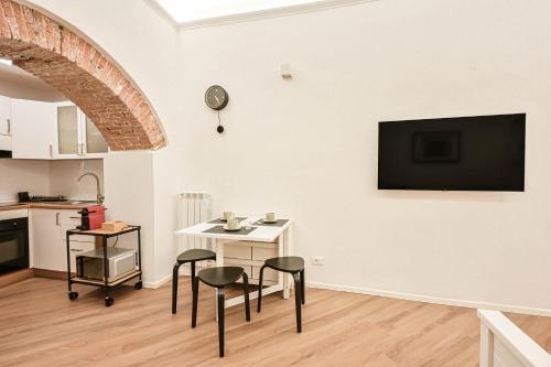 a living room with a table and chairs and a tv on the wall at Mascardi29 in Sarzana