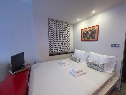 a bedroom with a white bed with towels on it at Anastasia's cozy studio in Nea Plagia
