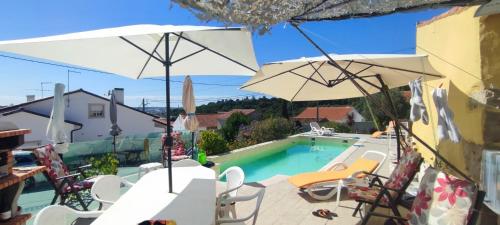 a pool with chairs and umbrellas next to a building at Kyrios Arts Atelier with use of private swimming pool in Carrascal