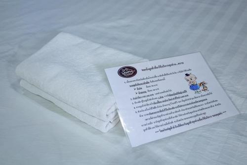 a piece of paper sitting on top of a white towel at Full House Udon in Ban Bo Nam