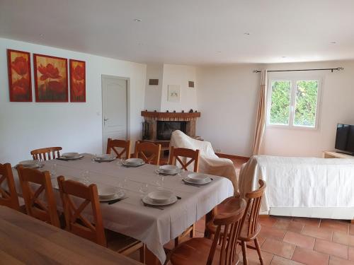 a dining room with a table and chairs and a fireplace at Gîte des Falaises 10 à 12 personnes in Souspierre