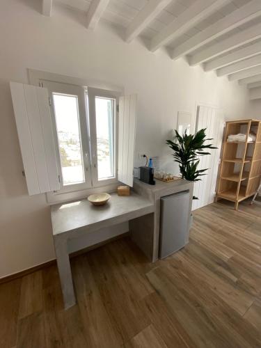 a kitchen with a bench in a room with windows at THE VIEW OF MYKONOS in Mýkonos City