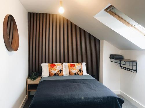 a bedroom with a bed with a black accent wall at Bee Stays - Rostherne House in Warrington