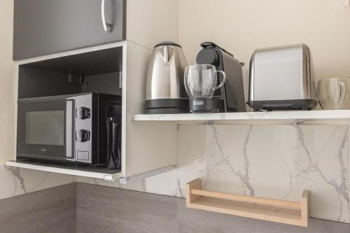 - une étagère de cuisine avec un four micro-ondes et un mixeur dans l'établissement Lovely Studio in Paris XVI, à Paris