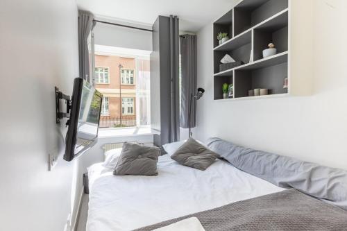 une petite chambre avec un lit et une fenêtre dans l'établissement Lovely Studio in Paris XVI, à Paris