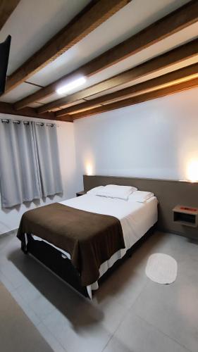 a bedroom with a large bed in a room at Pousada BRAWAY in Curitiba