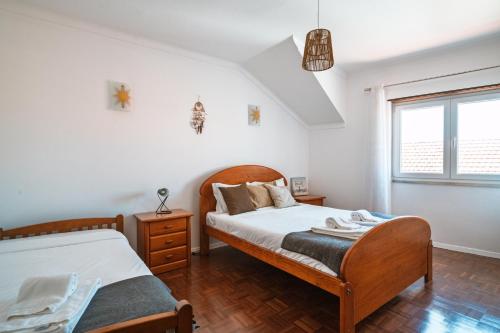 una camera da letto con due letti e una finestra di Casa Estrela do Mar a Ericeira