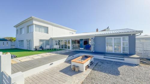 a blue house with a patio and a backyard at Die Lig-Huis Struisbaai in Struisbaai