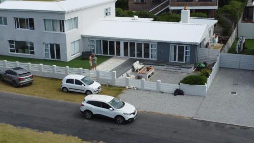 a white car parked in front of a house at Die Lig-Huis Struisbaai in Struisbaai