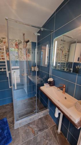 a blue bathroom with a sink and a shower at Central Riverside Apartments in Jēkabpils