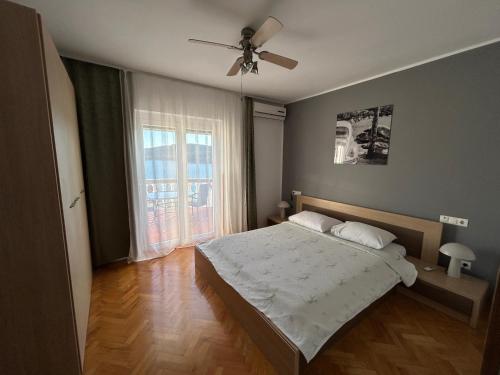 a bedroom with a bed and a ceiling fan at Apartments Perina Tisno in Tisno