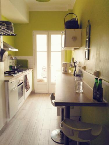 - une cuisine avec des murs verts et un comptoir en bois dans l'établissement Joli 2 pièces à 2 min de la plage, à Nice