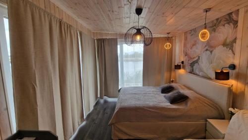 a bedroom with a bed and a large window at Central Riverside Apartments in Jēkabpils