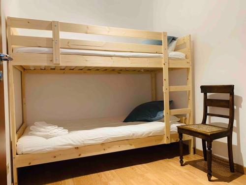 a wooden bunk bed with a chair and a desk at Póvoa TOP - Beachfront in Póvoa de Varzim