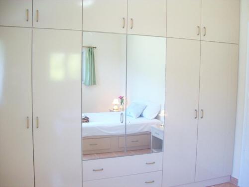 a bathroom with white cabinets and a mirror at Villa Vania in Vitalades