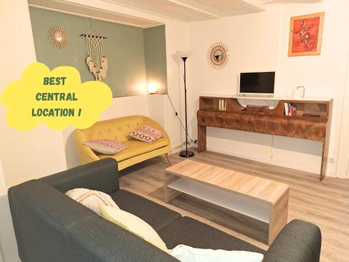 un salon avec un canapé et une table dans l'établissement Charmant et spacieux appartement au centre ville - La Bohème, à Mulhouse