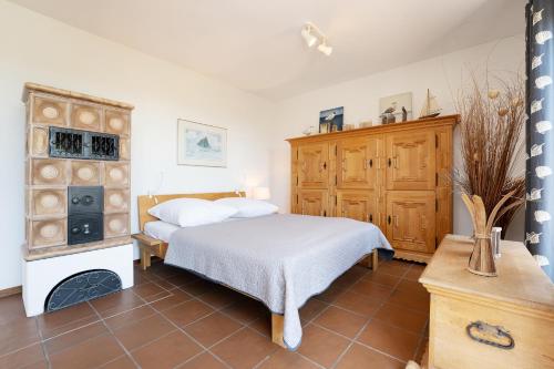 a bedroom with a bed and a wooden cabinet at Ferienhaus May App 1 in Sahrensdorf