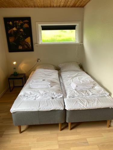 two beds in a room with a window at 2BR Home with Sea Views and Parking - Tórshavn in Tórshavn