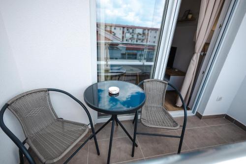a glass table and two chairs on a balcony at Apartman Anika Banja Koviljača in Banja Koviljača