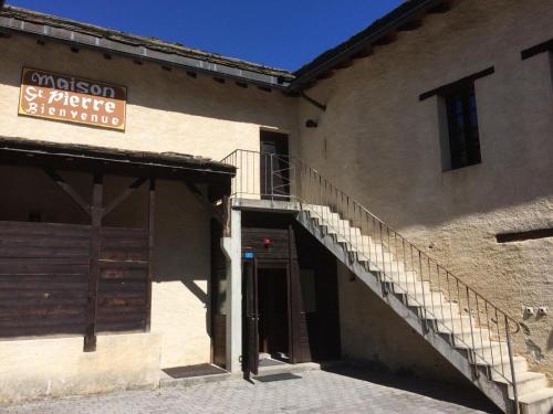 a building with a staircase and a sign on it at Maison St-Pierre in Bourg-Saint-Pierre
