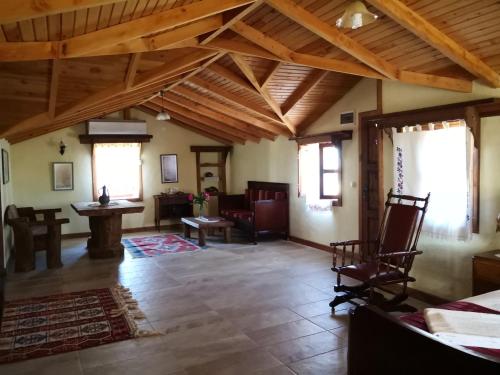 a living room with wooden ceilings and a room with chairs at Hoyran Wedre Country Houses in Davazlar