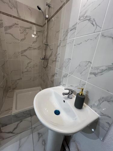 une salle de bain blanche avec un lavabo et une douche dans l'établissement Casa Bianca, à Marseille