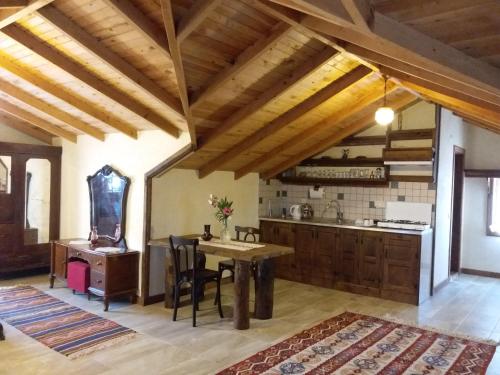 a kitchen with wooden ceilings and a table and chairs at Hoyran Wedre Country Houses in Davazlar