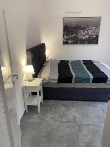a bedroom with a bed and a table with a lamp at Villa Aldina Apartment 2 in Bihać