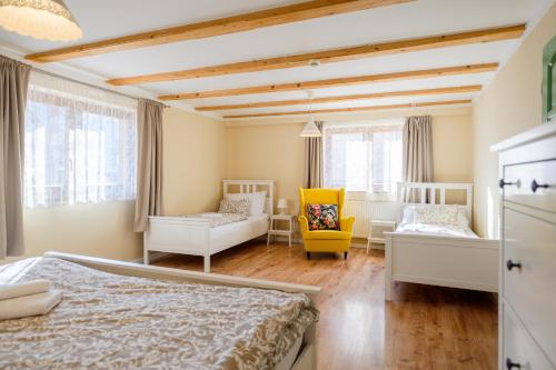 a bedroom with a bed and a yellow chair at Turciansky dvor in Martin