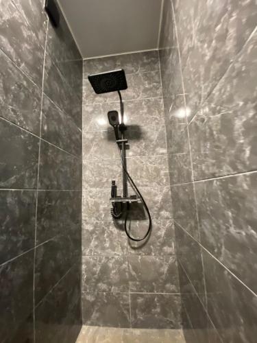 a shower with a shower head in a bathroom at Leveta Botanical Garden in Batumi
