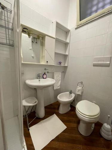 a white bathroom with a toilet and a sink at Violet House in Palermo
