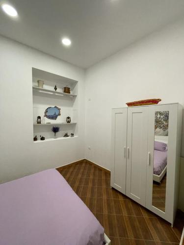 a bedroom with a bed and a small cabinet at Violet House in Palermo