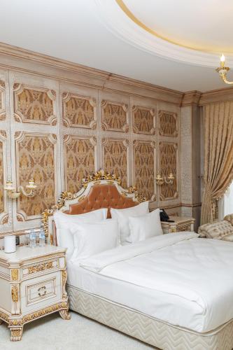 a bedroom with a large white bed and a table at Ayan Palace Hotel in Tovuz