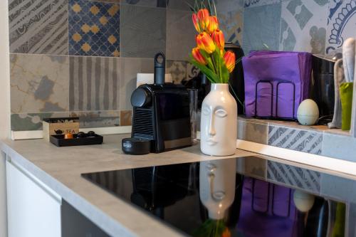 a kitchen counter with a vase of flowers and a microwave at HI15 Apartment - Garage Privato in Como